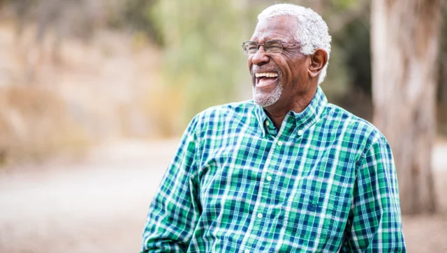 Portrait of a smiling older man outside.
