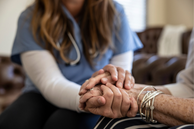 Nurse supporting a patient during hospice care at home visit.