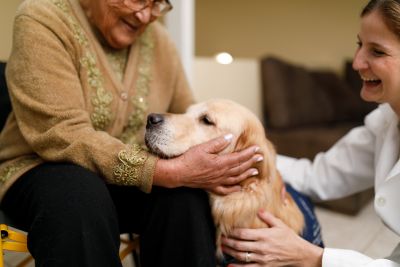 Pet therapy volunteer and a therapy dog visiting with a hospice patient