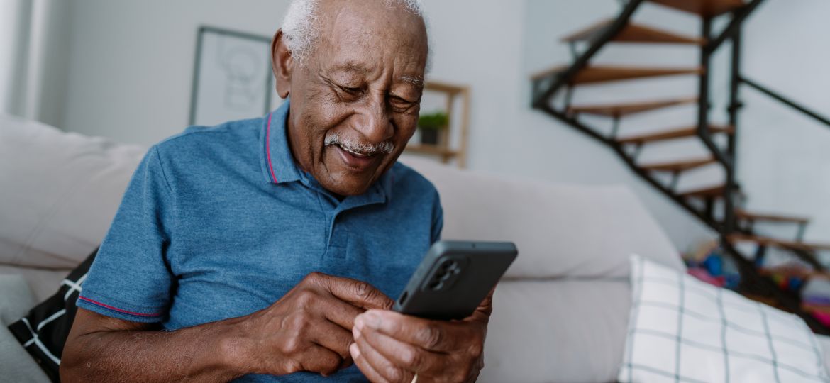 Elderly man using smartphone at home